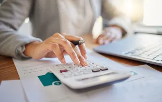 Hand with calculator and paperwork