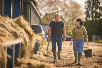 Man and woman smiling walking in a farm
