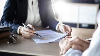 Women with pen in hand going over paperwork