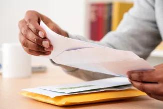 Man opening letter at table