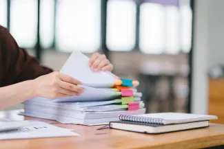 Woman flipping through stack of funded litigation paperwork