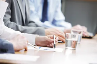 Hands at table with paperwork during business meeting