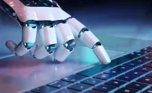 Robot hand on keyboard